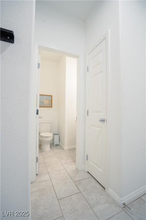 bathroom featuring baseboards and toilet