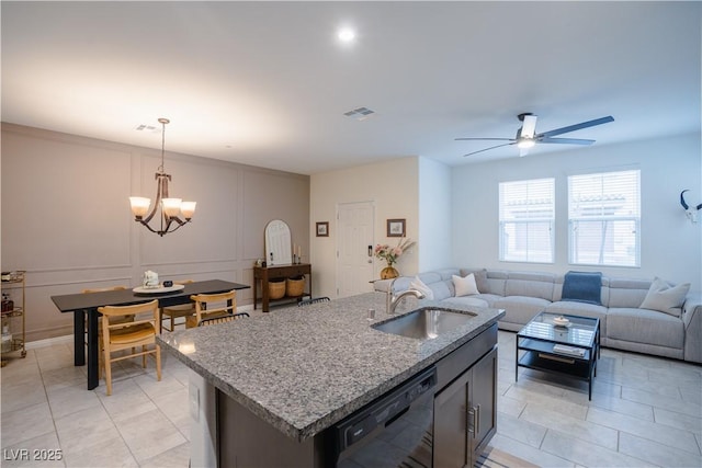 kitchen with visible vents, a sink, decorative light fixtures, a decorative wall, and dishwasher