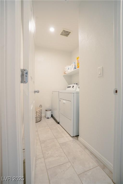 laundry room with laundry area, washing machine and dryer, baseboards, and visible vents