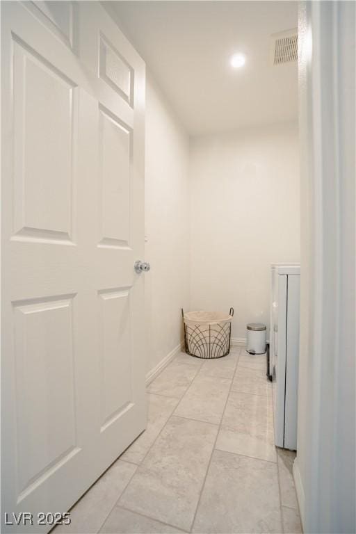 hallway with visible vents and baseboards