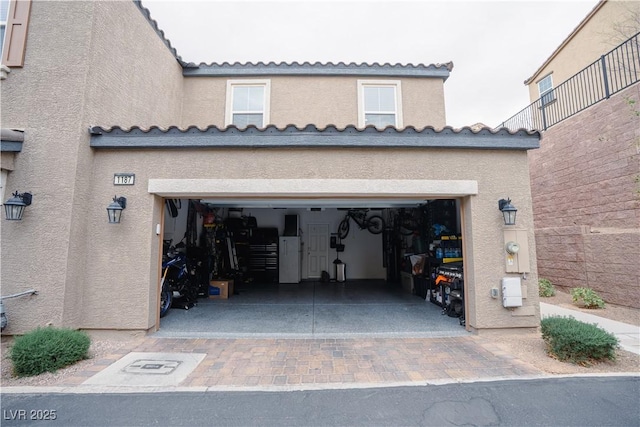 garage with decorative driveway