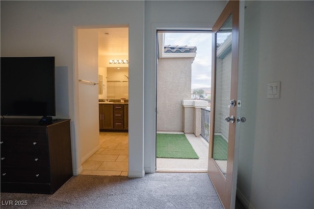 entryway with light tile patterned floors and light carpet