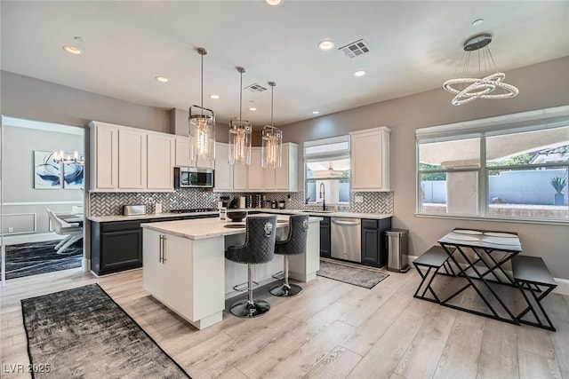 kitchen with visible vents, a chandelier, light countertops, stainless steel appliances, and a sink