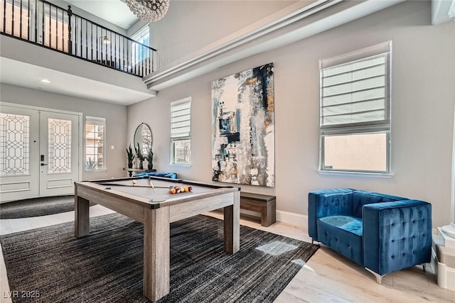 game room with wood finished floors, baseboards, a high ceiling, pool table, and french doors