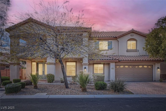 mediterranean / spanish-style house with stucco siding, driveway, and a tile roof