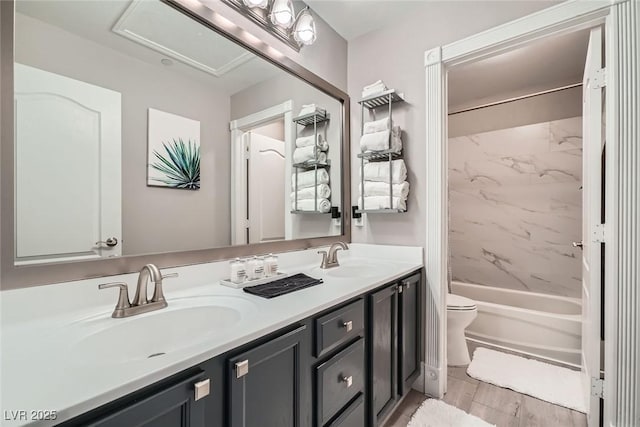 full bathroom with double vanity, wood finish floors, toilet, and a sink