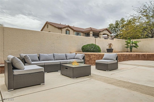 view of patio with an outdoor living space with a fire pit and a fenced backyard