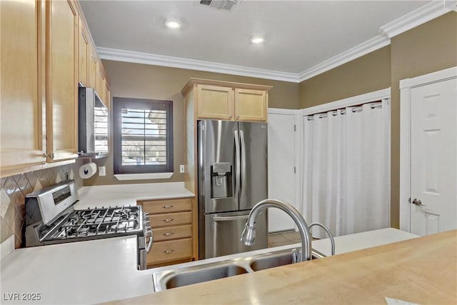 kitchen featuring crown molding, light brown cabinets, appliances with stainless steel finishes, and a sink