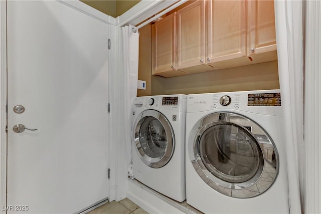 washroom featuring light tile patterned floors, washing machine and dryer, and cabinet space