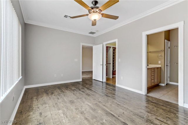 unfurnished bedroom with baseboards, wood finished floors, and crown molding