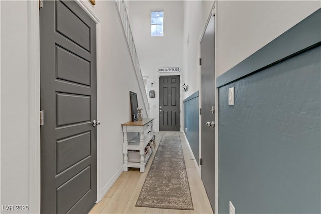 hall with light wood finished floors and baseboards