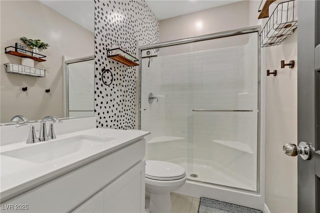 bathroom featuring vanity, toilet, and a stall shower