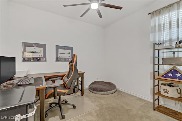 carpeted home office with baseboards and a ceiling fan