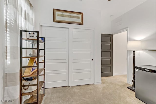 interior space featuring light colored carpet and baseboards