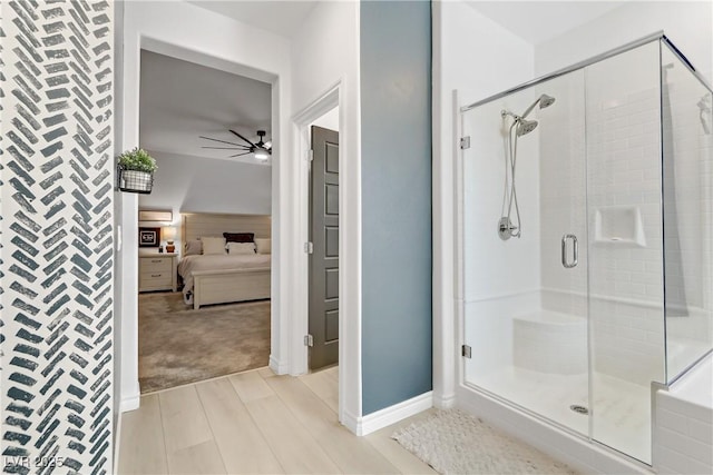 ensuite bathroom with baseboards, a shower stall, ensuite bath, and a ceiling fan