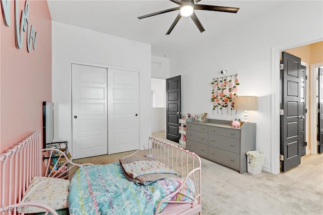 bedroom with radiator heating unit, a ceiling fan, a closet, and light carpet