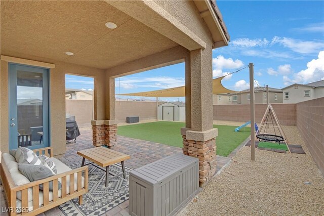 view of patio / terrace with an outdoor structure, a fenced backyard, an outdoor living space, and a shed