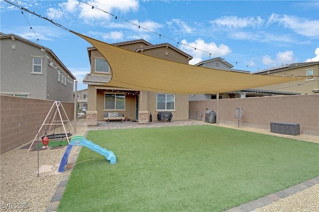 rear view of property with stucco siding, a patio, a yard, and a fenced backyard