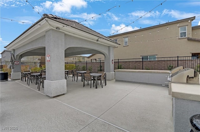 view of patio with outdoor dining area, area for grilling, exterior kitchen, and fence