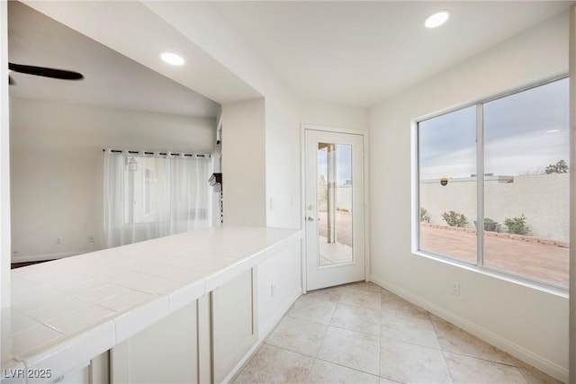 hallway featuring light tile patterned floors, recessed lighting, and baseboards