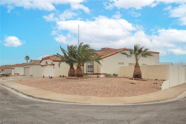 view of front of property featuring stucco siding, driveway, an attached garage, and a tiled roof