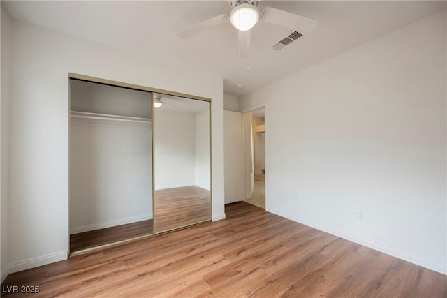 unfurnished bedroom with visible vents, a ceiling fan, a closet, light wood-style floors, and baseboards