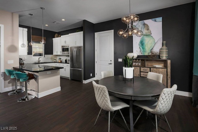 dining space with dark wood-type flooring, visible vents, and baseboards