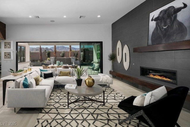 living area featuring recessed lighting, a mountain view, visible vents, and a tiled fireplace