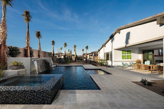 pool with a patio and a hot tub