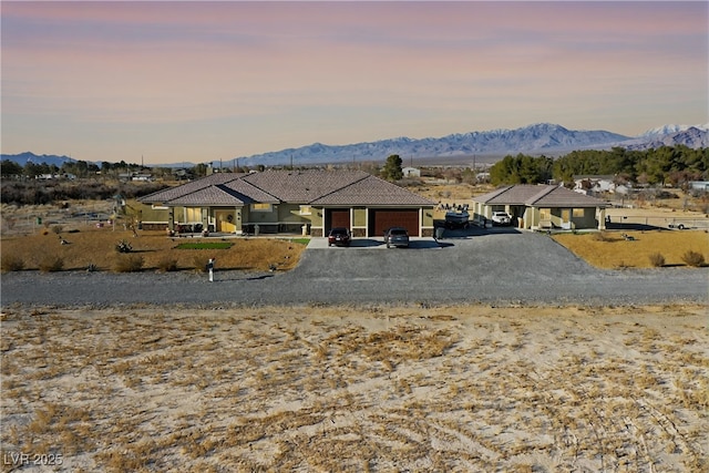 view of front of property featuring a mountain view, a tile roof, and driveway