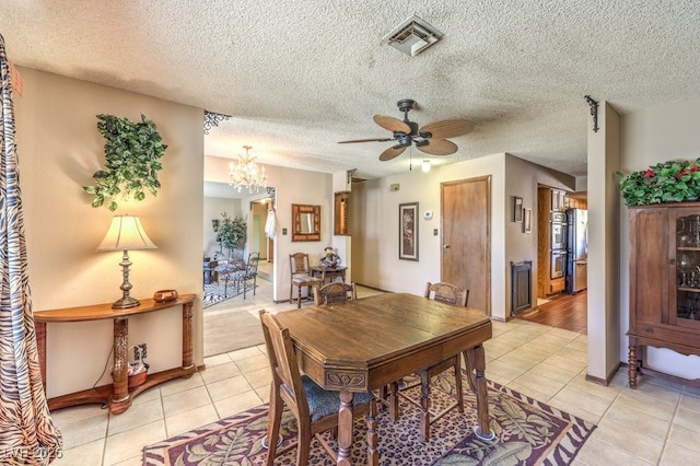10615 Rancho Destino Rd, Las Vegas, NV 89183 - dining room with light tile patterned floors, visible vents, ceiling fan with notable chandelier, and a textured ceiling