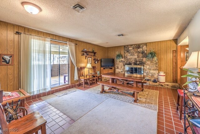 10615 Rancho Destino Rd, Las Vegas, NV 89183 - living room featuring tile patterned flooring, visible vents, a fireplace, and wooden walls