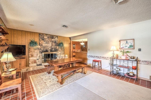10615 Rancho Destino Rd, Las Vegas, NV 89183 - living room with a fireplace, visible vents, wood walls, and a textured ceiling