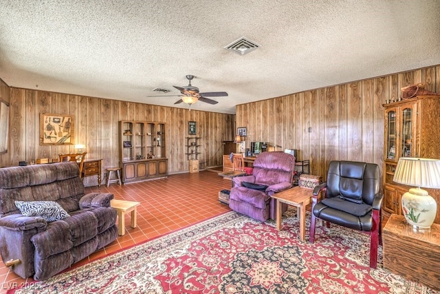 10615 Rancho Destino Rd, Las Vegas, NV 89183 - tiled living room featuring visible vents, wooden walls, a textured ceiling, and a ceiling fan