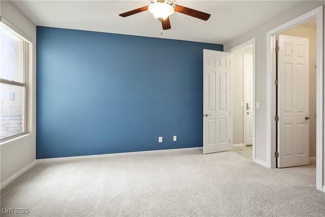 carpeted spare room with baseboards and ceiling fan