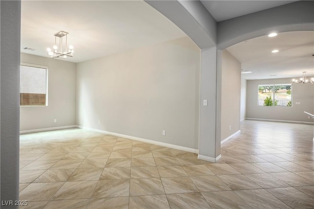 unfurnished room featuring visible vents, recessed lighting, arched walkways, baseboards, and a chandelier