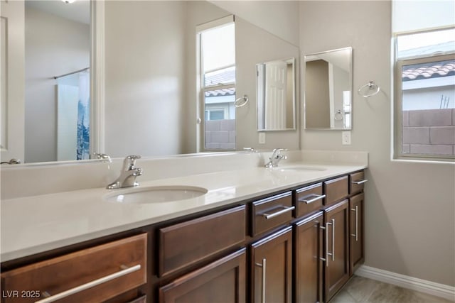 full bath with a sink, double vanity, and tile patterned floors