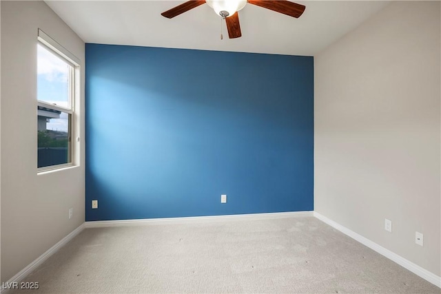 empty room featuring carpet flooring, baseboards, and ceiling fan