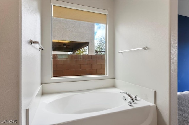 full bath with a garden tub and ceiling fan