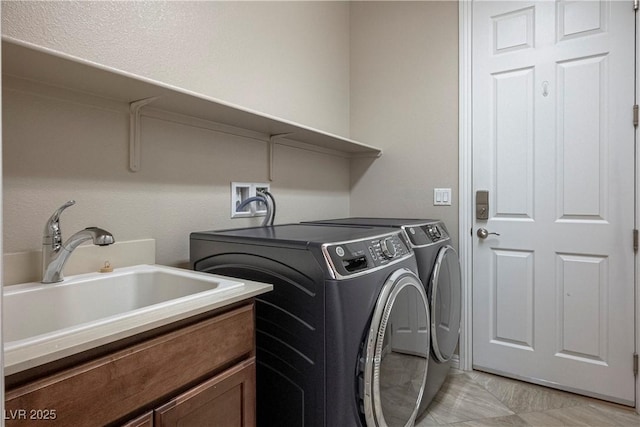 washroom with a sink, laundry area, and washer and clothes dryer