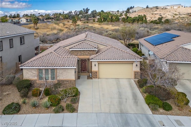 view of front of home with concrete driveway, a tile roof, stucco siding, a garage, and stone siding