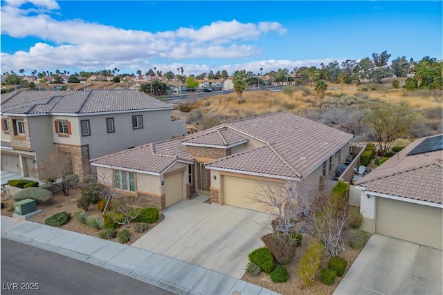 view of front of property with driveway, an attached garage, stucco siding, stone siding, and a residential view