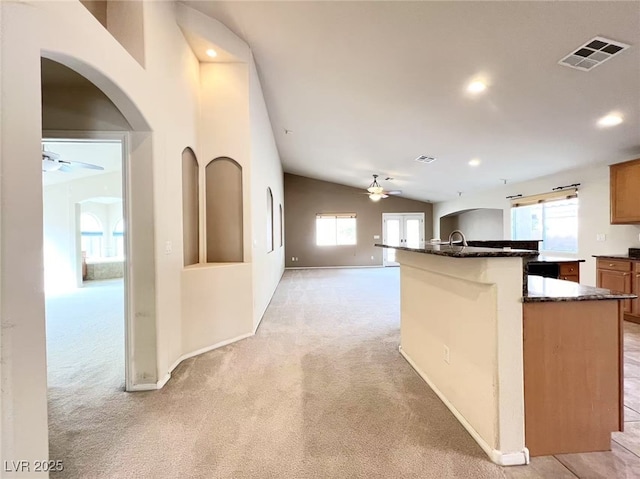 kitchen with visible vents, light colored carpet, plenty of natural light, and a ceiling fan