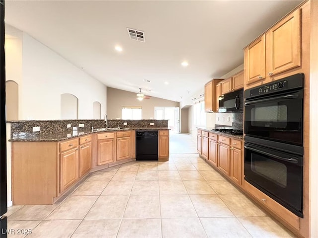 kitchen featuring light tile patterned floors, visible vents, a sink, black appliances, and vaulted ceiling