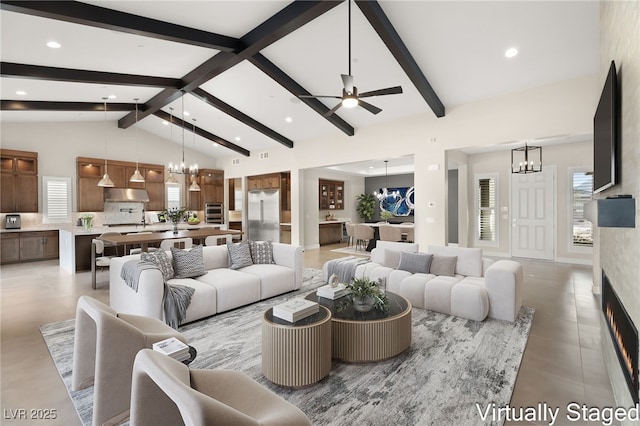 living area featuring beam ceiling, high vaulted ceiling, ceiling fan with notable chandelier, a large fireplace, and light tile patterned floors