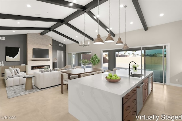 kitchen featuring pendant lighting, a kitchen island with sink, a wealth of natural light, and a sink