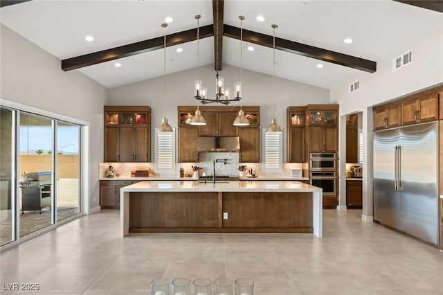 kitchen featuring light countertops, tasteful backsplash, visible vents, and stainless steel appliances