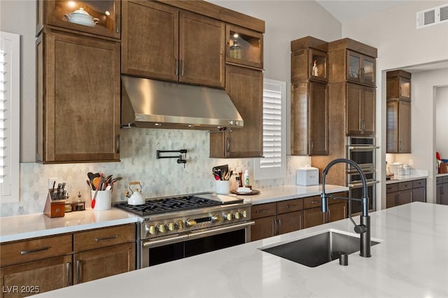 kitchen featuring visible vents, a sink, light countertops, appliances with stainless steel finishes, and under cabinet range hood