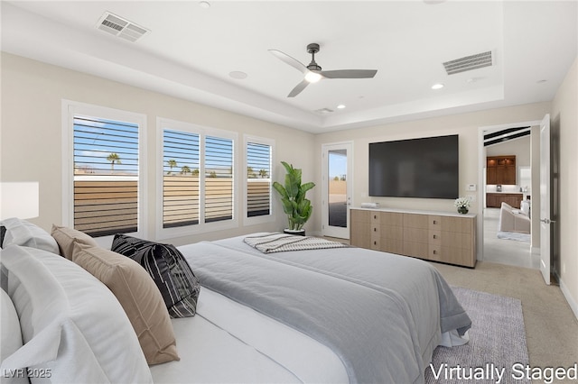 bedroom with a tray ceiling, visible vents, and recessed lighting