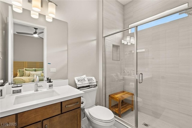 bathroom with a shower stall, ceiling fan, toilet, ensuite bath, and vanity